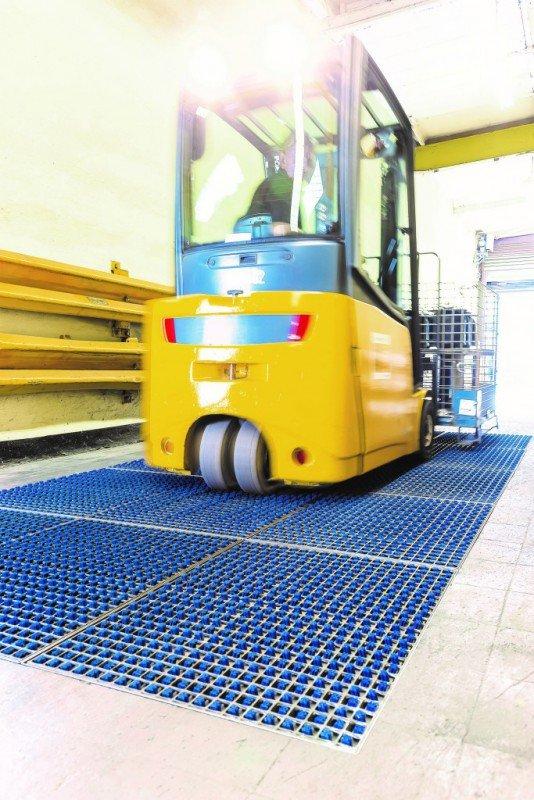 Empilhadeira amarela passando sobre o sistema ProfilGate instalado no chão do galpão